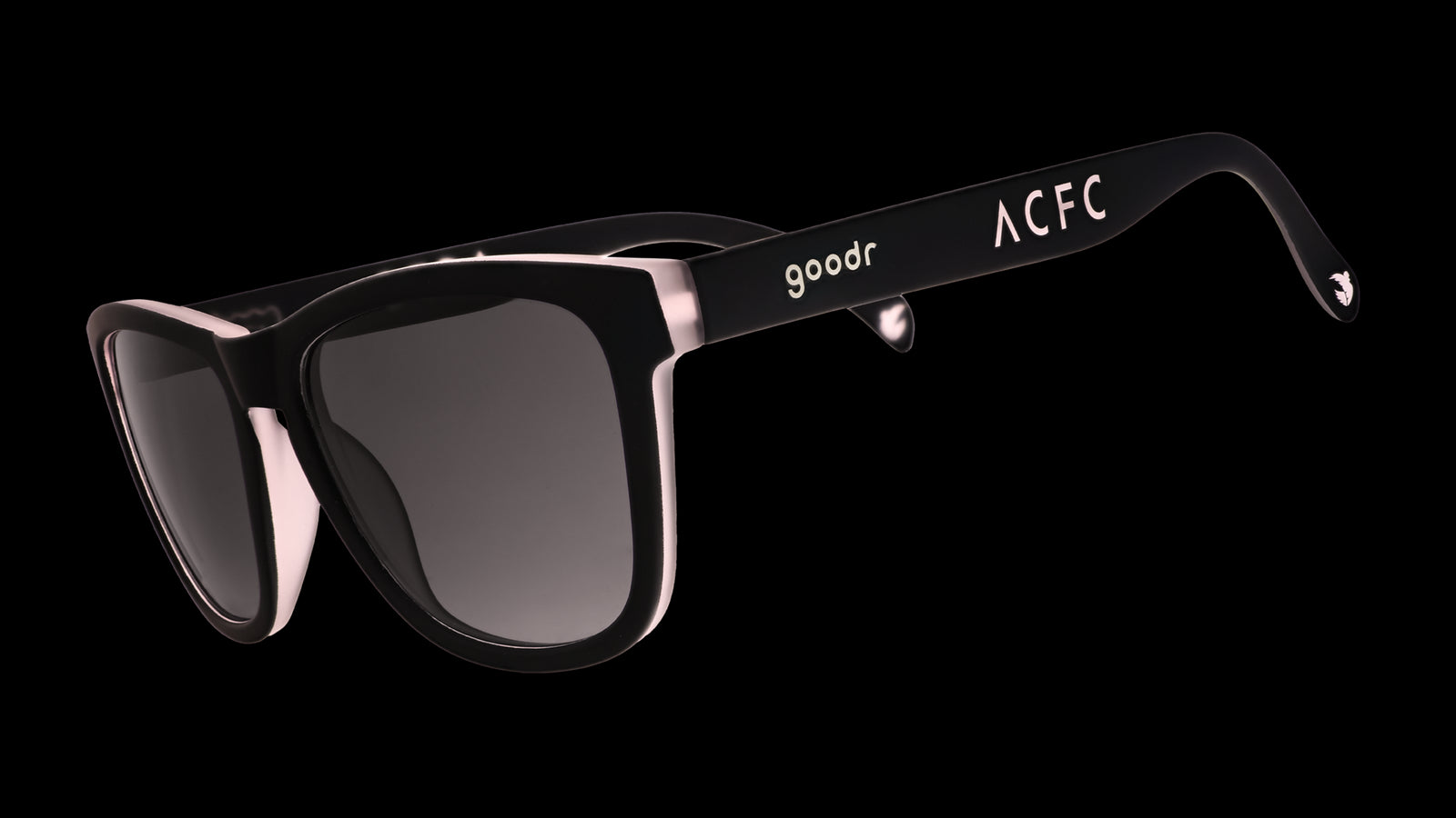 Three-quarter angle view of black and pink sunglasses with black gradient lenses and ACFC logo.