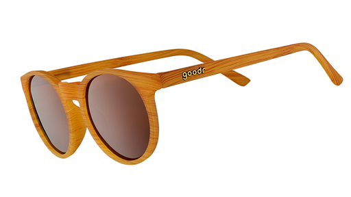 Three-quarter angle view of sunglasses with brown wood grain patterned circle frames, non-reflective round brown lenses.