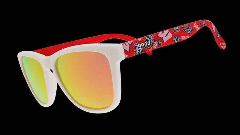 A pair of "goodr" sunglasses with white frames and reflective orange-gold lenses. The arms of the sunglasses are red and feature the University of Wisconsin’s mascot, Bucky Badger, along with bold "W" logos and other school-themed graphics.