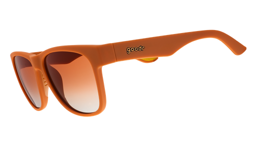 Three-quarter angle view of large brown sunglasses with orange-gold ocean gradient lenses.