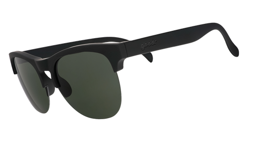 Three-quarter angle view of matte black half-rim sunglasses with dark green non-reflective lenses.