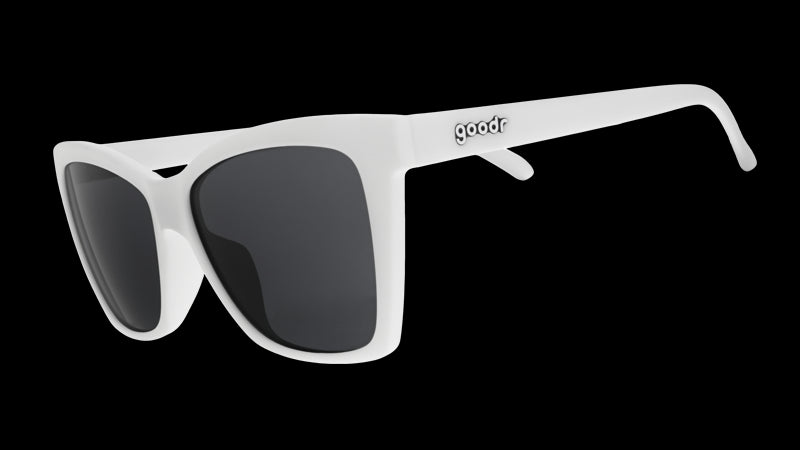 Three-quarter angle view of white angled cat-eye sunglasses with non-reflective black lenses.