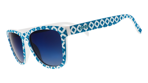 Three-quarter angle view of a pair of blue-and-white tile-print sunglasses with blue gradient lenses.