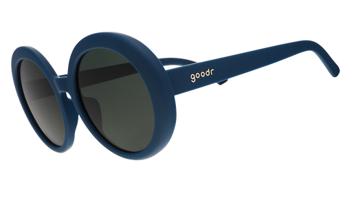 Three-quarter view of a pair of oversized, round sunglasses in a deep green with green non-reflective lenses.