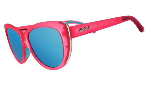 Cat-eye goodr sunglasses with pink frames and blue lenses on a white background.