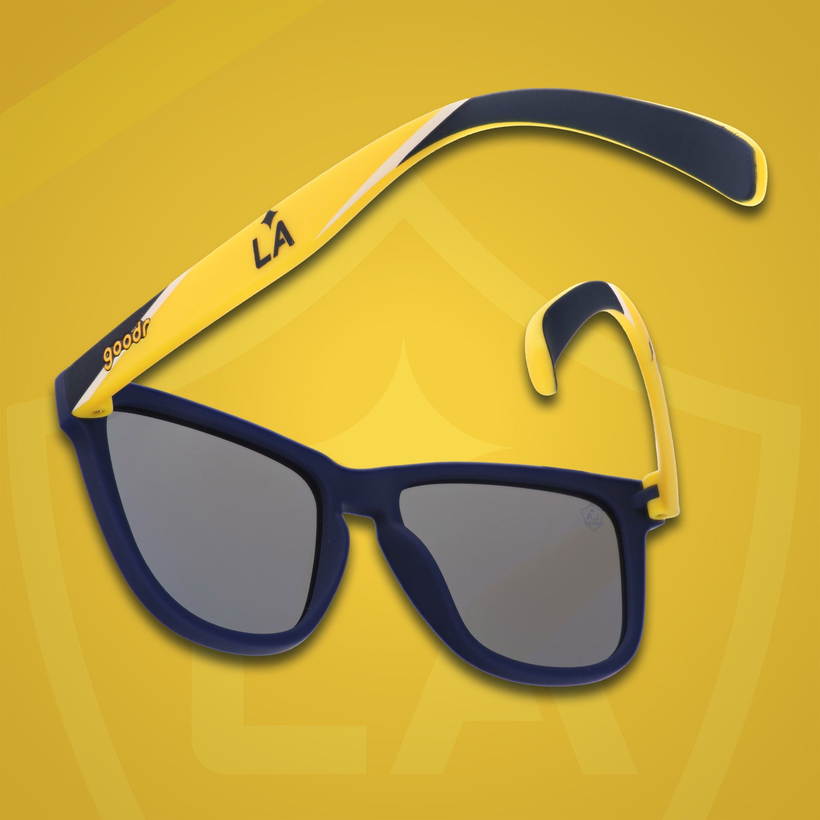 Three-quarter angle back view of MLS LA Galaxy shades on a yellow background. Navy+yellow frames. Blue lenses.