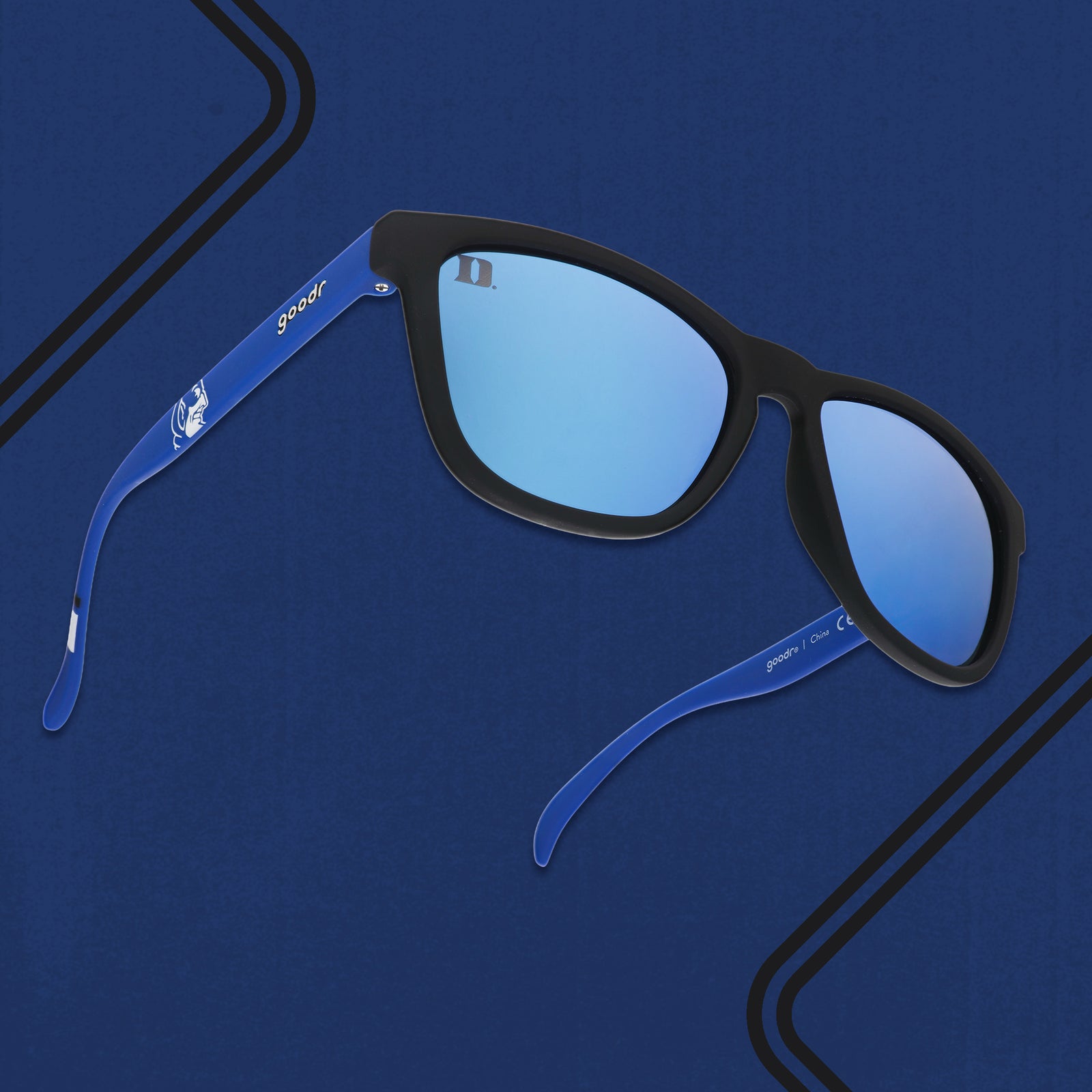 Three-quarter angle view of blue and black Duke University® Blue Devils® sunglasses with blue lenses on a blue background.