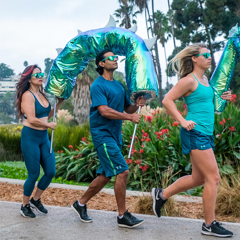 Three people running a race in teal clothing, wearing matching teal reflective sunglasses.
