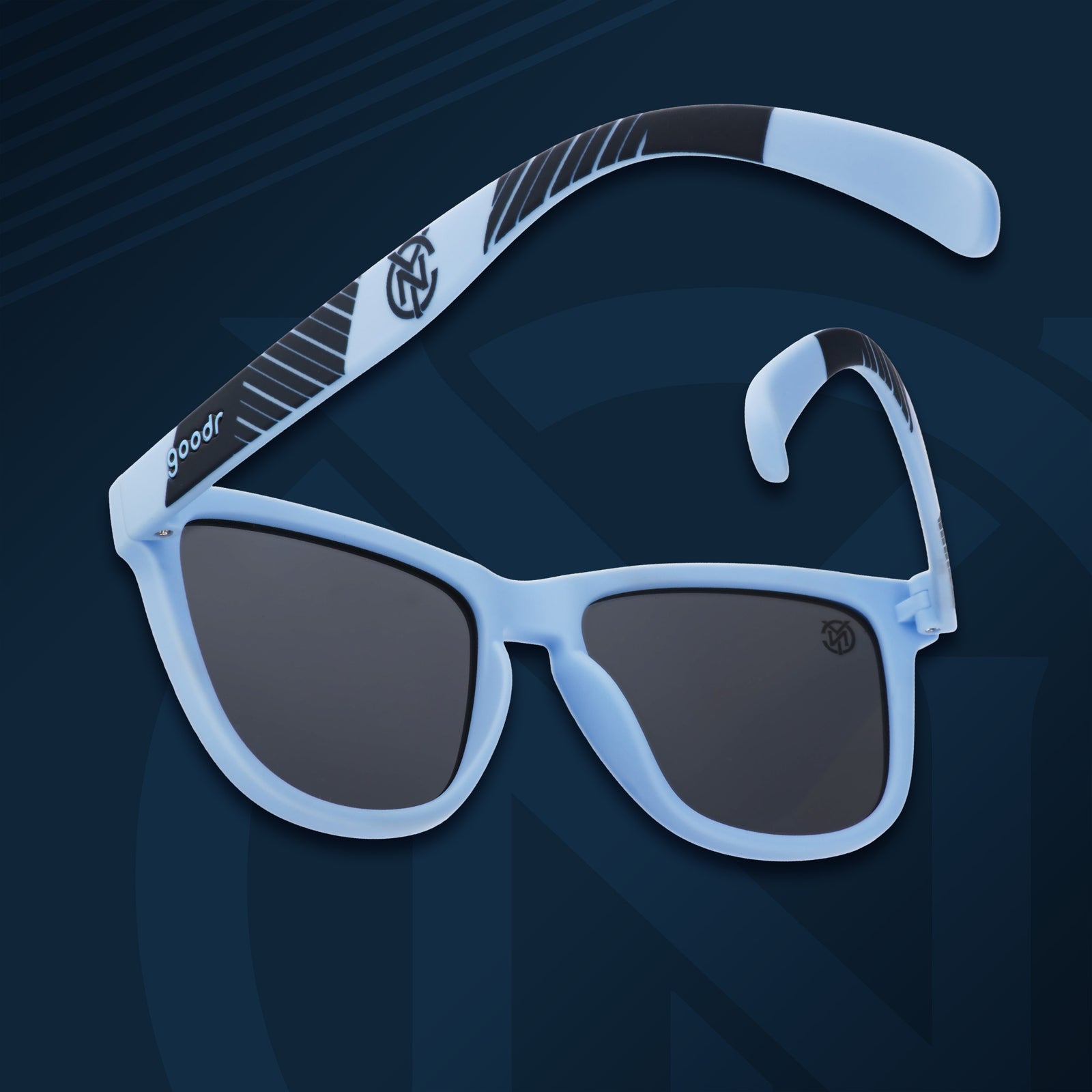 Three-quarter angle back view of NYCFC shades on a navy background. Light blue+navy frames. Black non-reflective lenses.