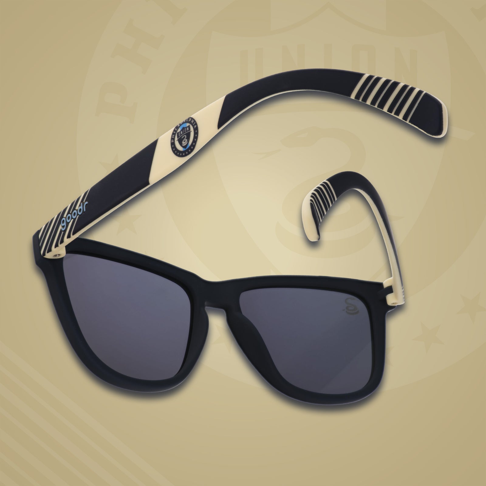 Three-quarter angle back view of MLS Philadelphia Union shades on a gold background. Navy+gold frames. Gold lenses.