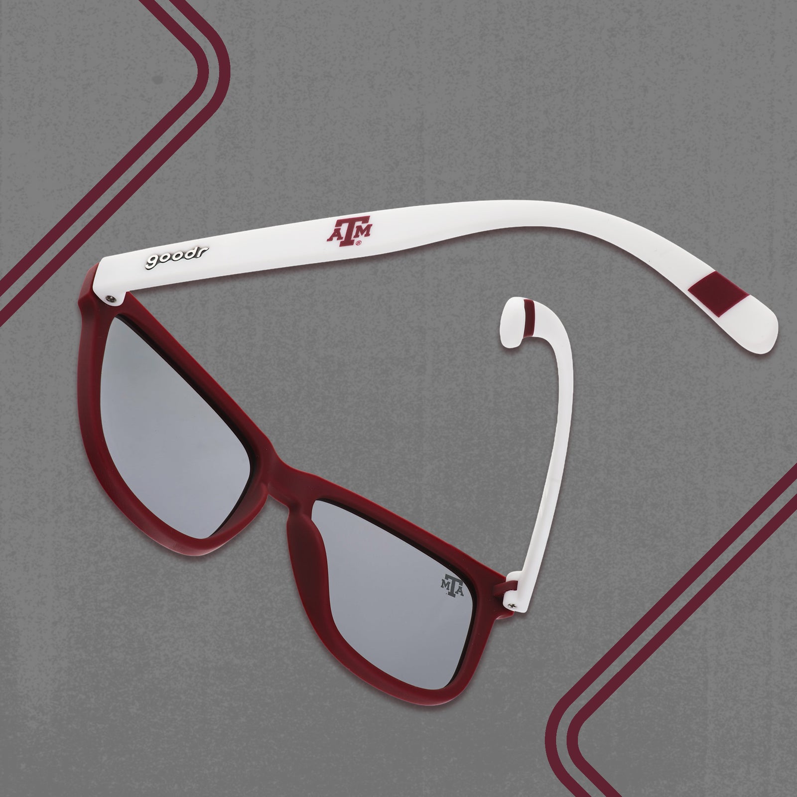 Three-quarter angle back view of white and burgundy Texas A&M® Aggies™ sunglasses with chrome lenses on a gray background.