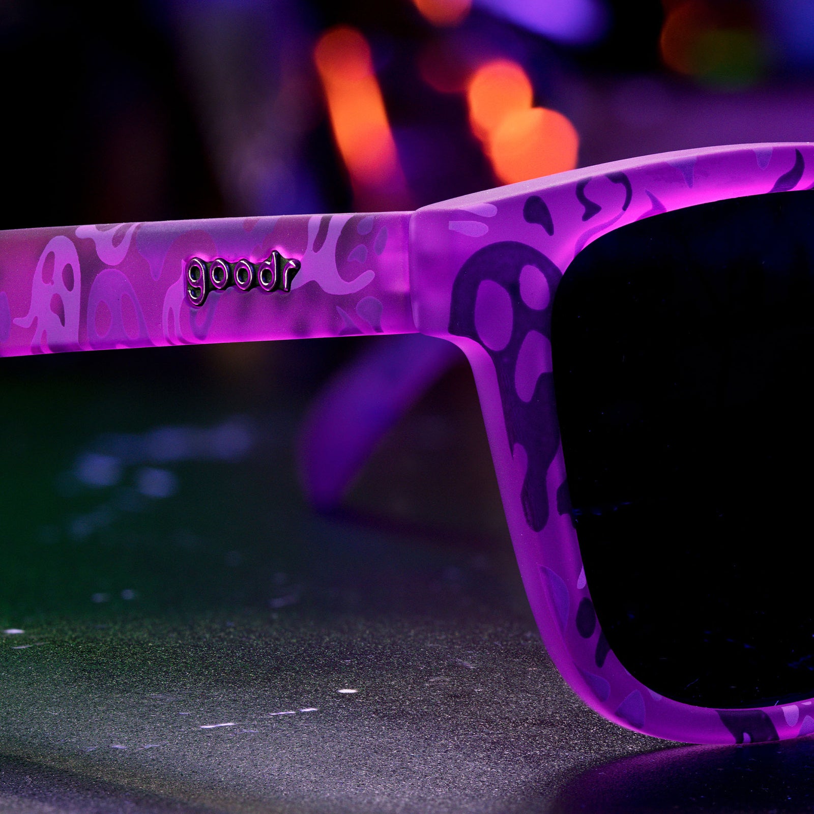 Three-quarter angle close-up of purple sunglasses featuring a phantom print and the goodr logo.