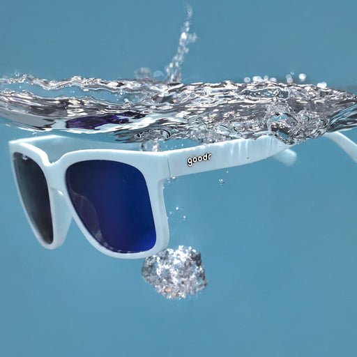 Three-quarter angle view of light blue sunglasses with blue lenses floating in the water after being dropped.