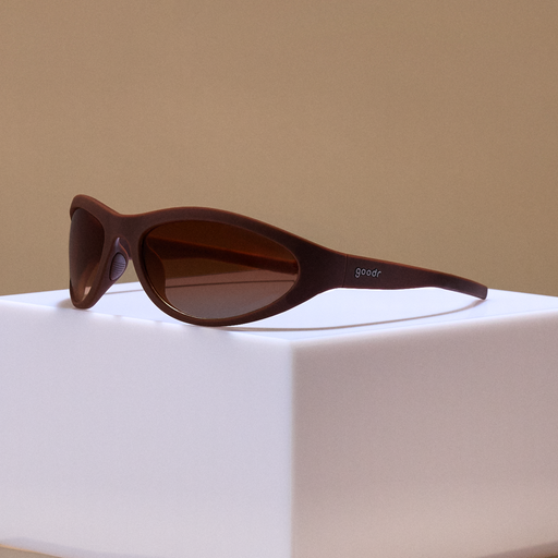 Three-quarter angle view of brown wraparound sunglasses with brown gradient lenses.