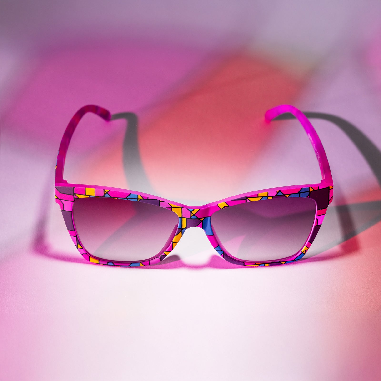 A pair of purple Pop Gs with a stained glass-inspired design on a white backdrop with a stained glass lighting effect.