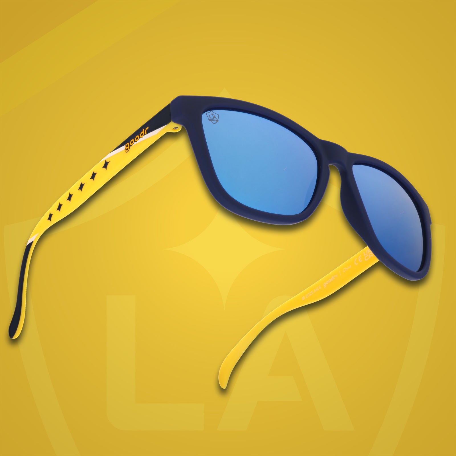 Three-quarter angle front view of MLS LA Galaxy shades on a yellow background. Navy+yellow frames. Blue lenses.