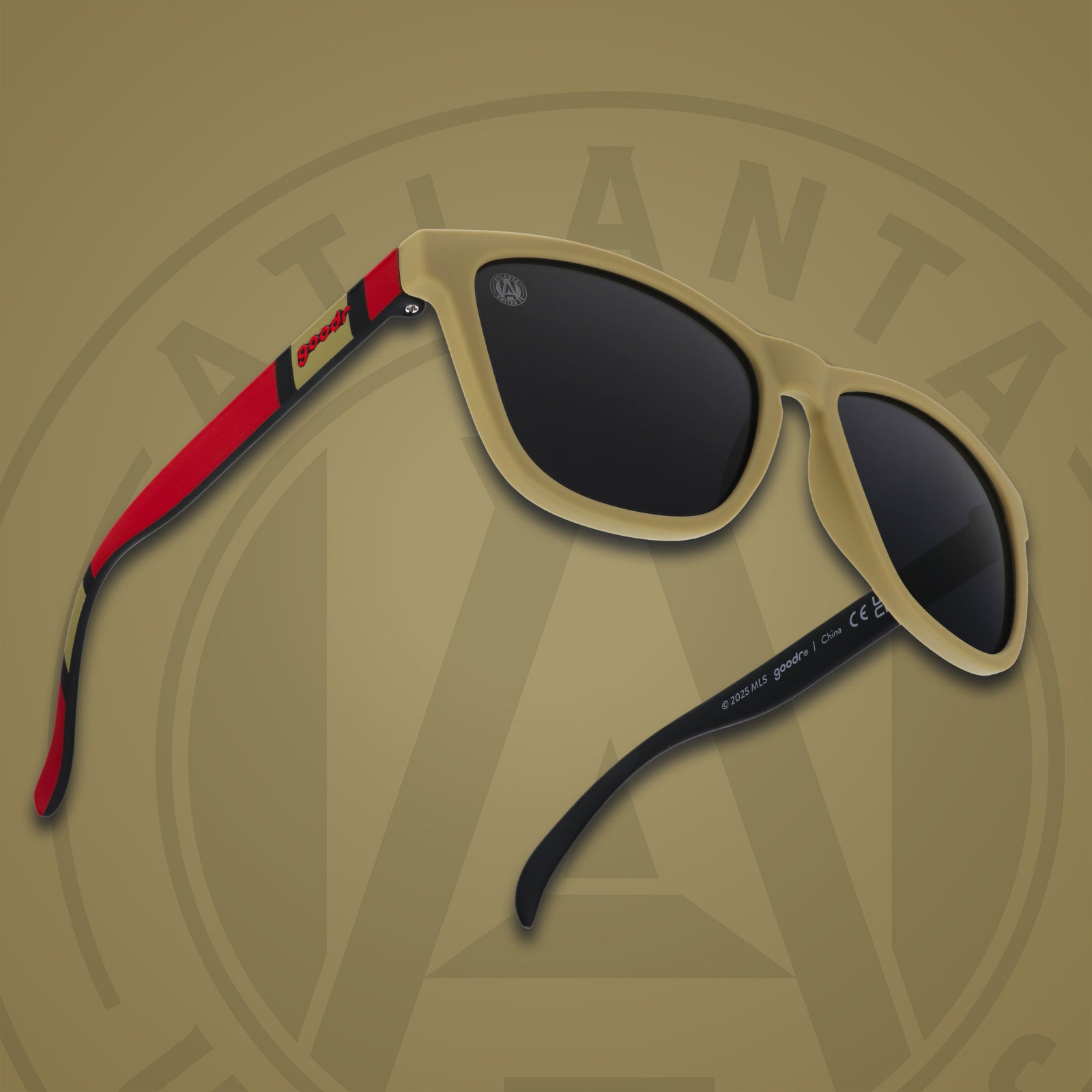 Three-quarter angle front view of MLS Atlanta United shades on a gold background. Gold+red frames. Black lenses.