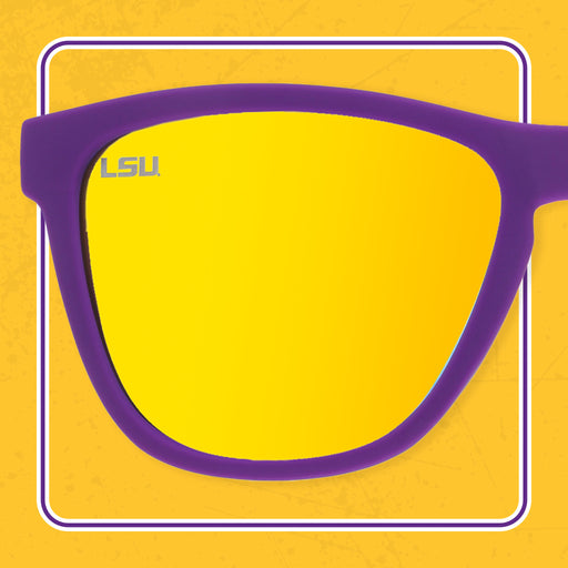 A pair of sunglasses with purple frames and reflective yellow lenses. The lenses feature an "LSU" logo in the top left corner, representing Louisiana State University.