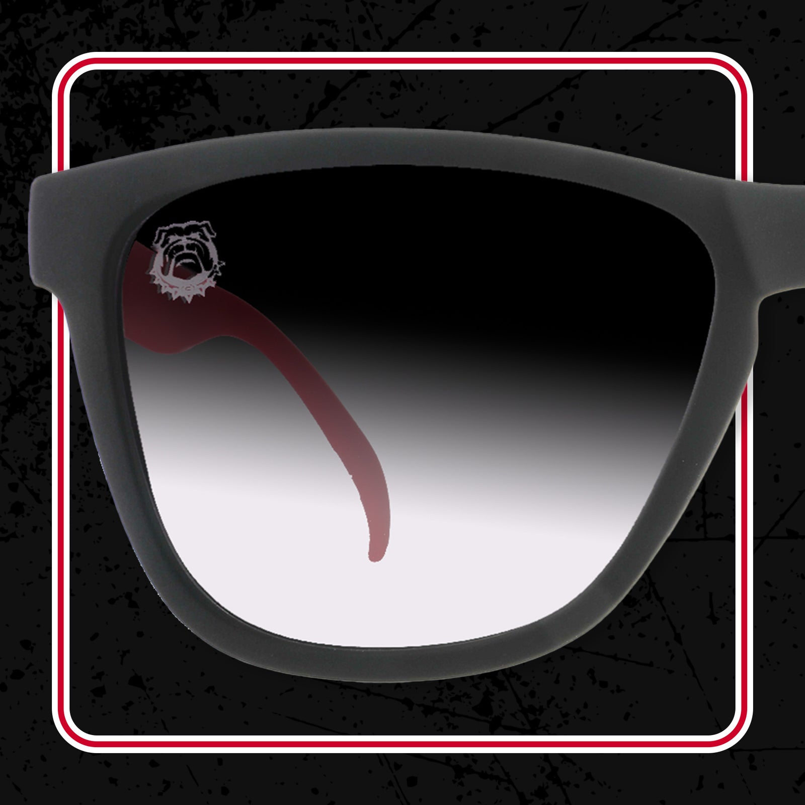 One lens of a pair of dark grey sunglasses, with a bulldog face in the top left of the lens