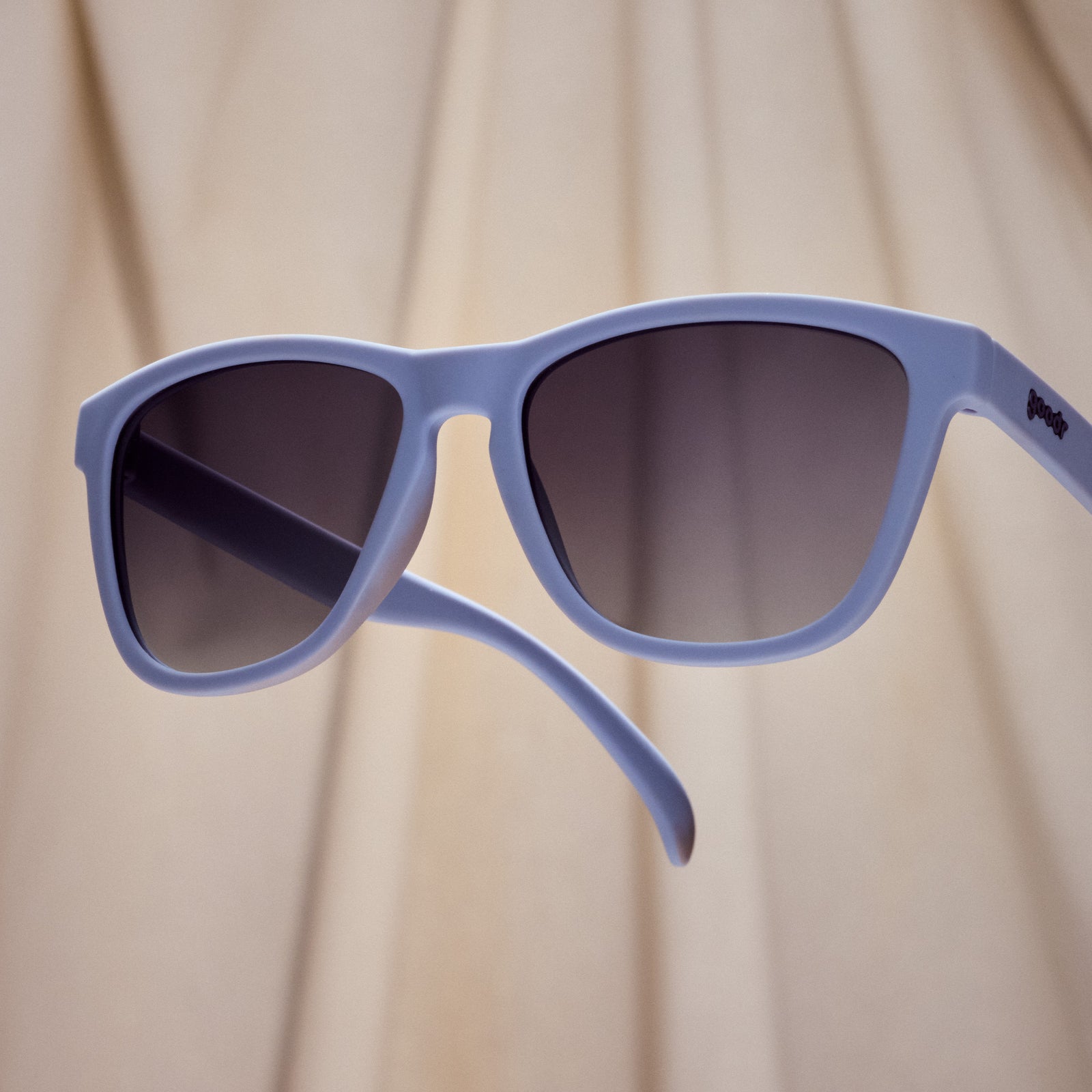 A pair of square sunglasses with lavender frames and lenses.