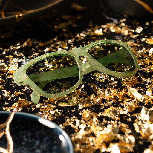 Full view of kintsugi shades with green lenses, green frames & gold crack accents on gold fragments by kintsugi pottery.