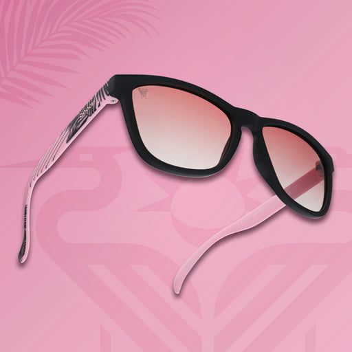 Three-quarter angle view of Inter Miami CF shades tilted up. Black and pink frames. Rose lenses. Pink background.