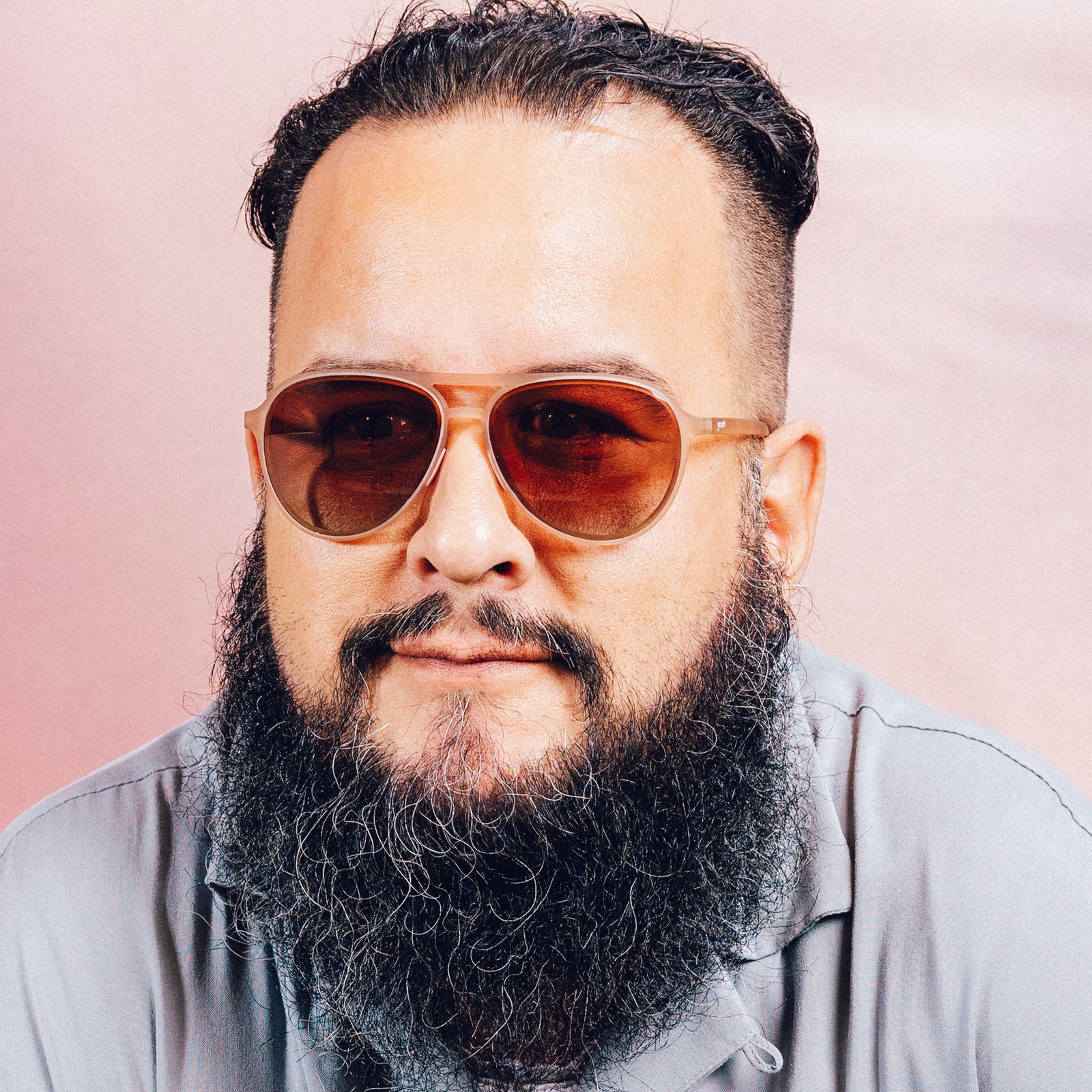Front view of a man wearing translucent pink aviator sunglasses with rose gradient lenses.