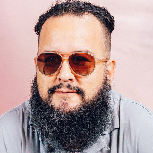 Front view of a man wearing translucent pink aviator sunglasses with rose gradient lenses.