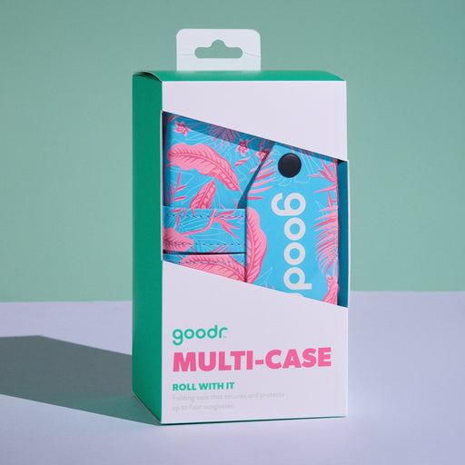 A white product box containing the pink and blue Roll With It multi-case is displayed on a white tabletop with a sage green backdrop.