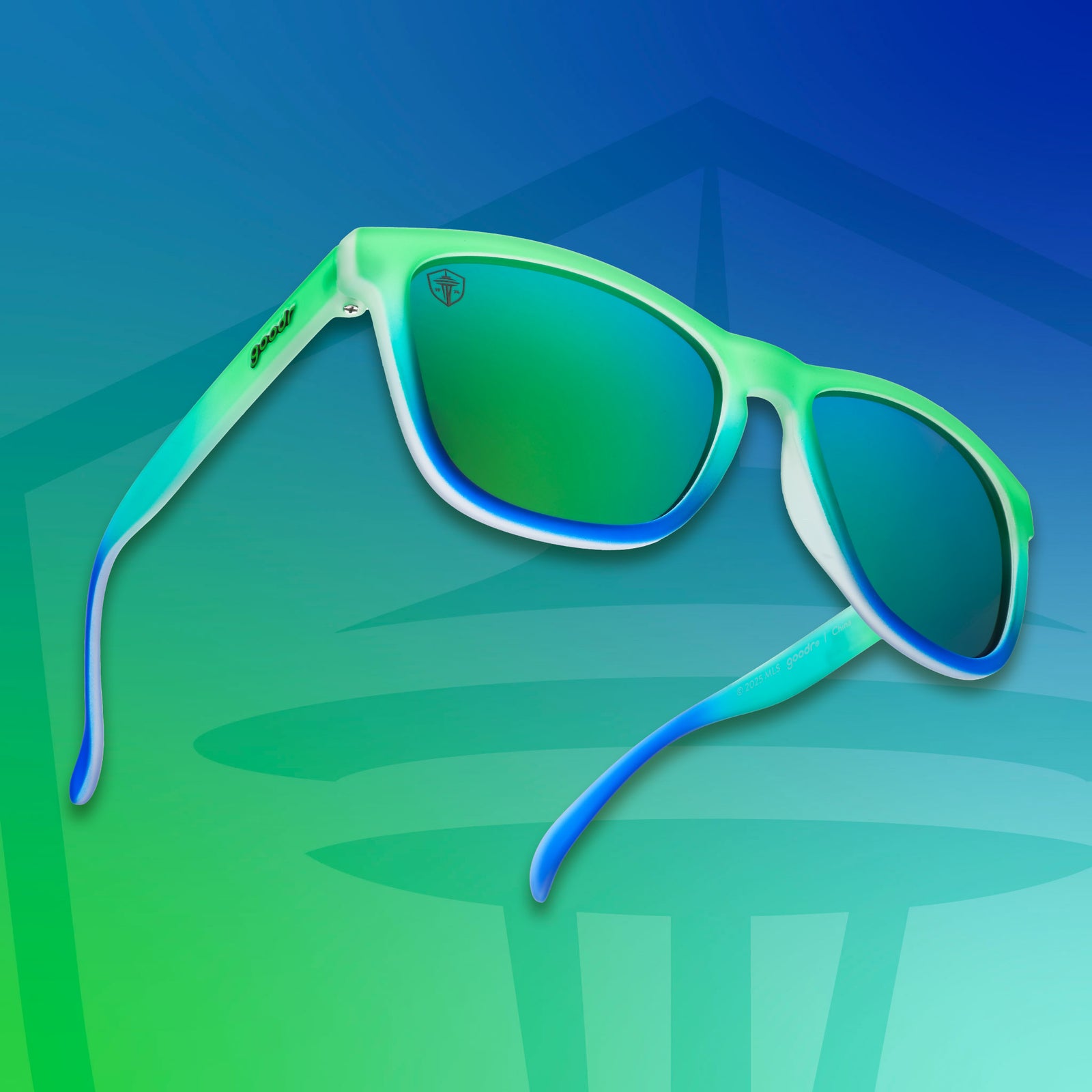 Three-quarter angle view of Seattle Sounders shades tilted up. Green-blue frames. Green lenses. Green-blue background.